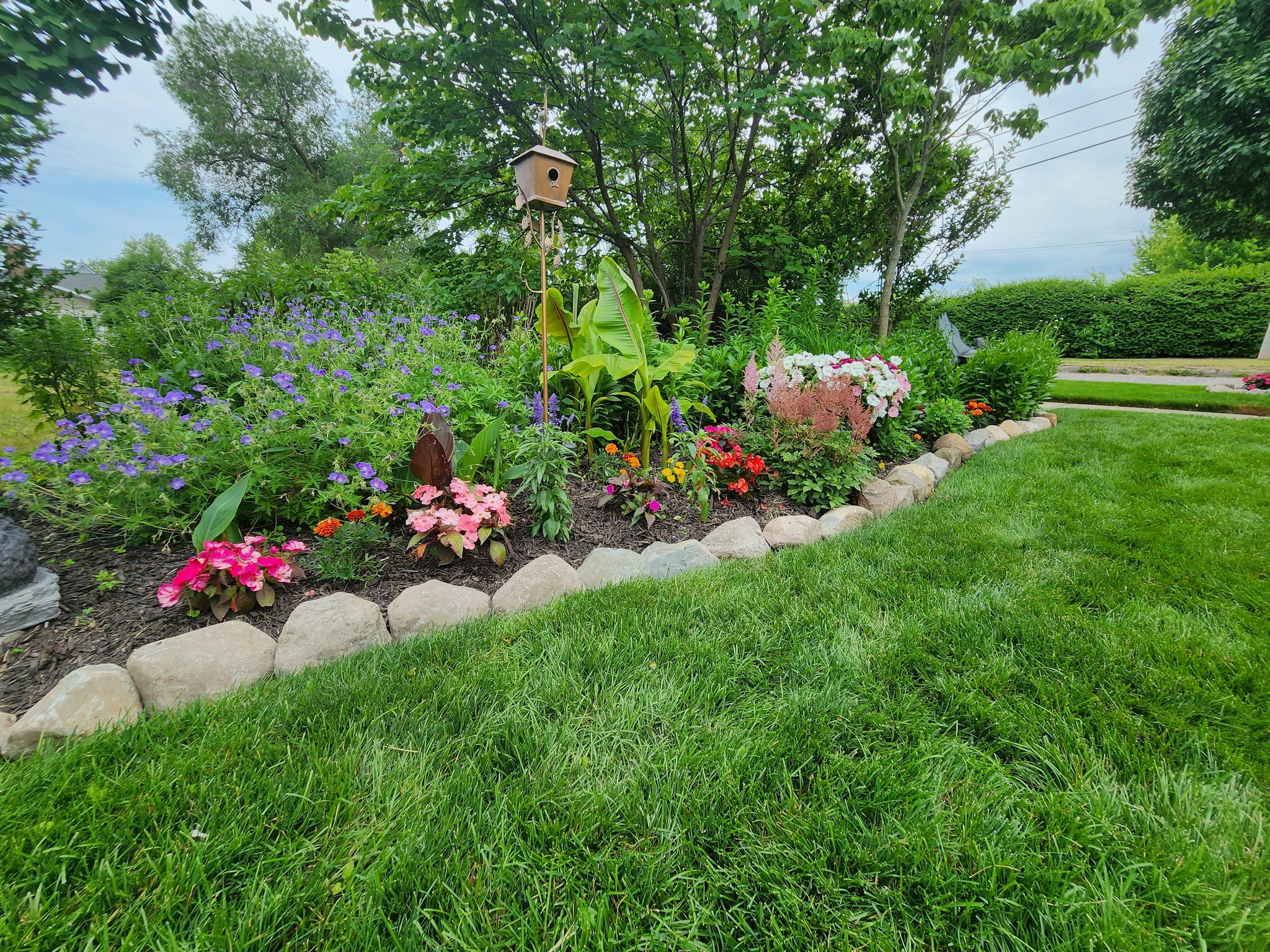 Colorful flower garden bed with natural stone border